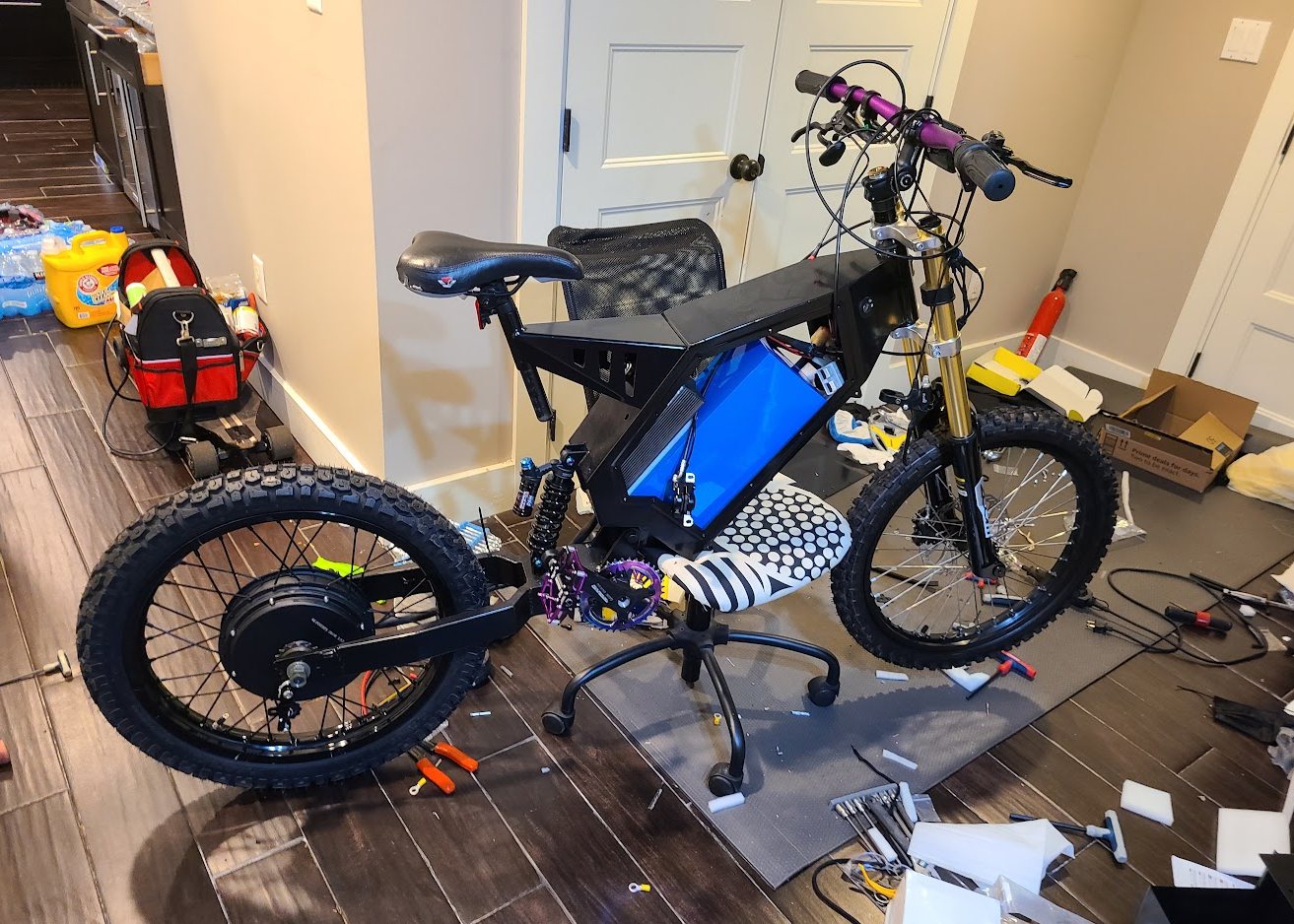 Assembled electric dirt bike with blue battery pack in the frame